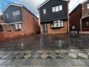 New block paving driveway with decorative diamond pattern edging outside semi-detached brick house